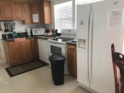 a kitchen with a white refrigerator and a trash can at La Jolla private Studio in San Diego