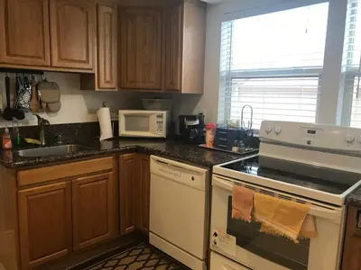 a kitchen with wooden cabinets and a white stove top oven at La Jolla private Studio in San Diego