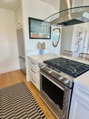a kitchen with an oven and a stove top at South O Surf House by Coastline Vacation Rentals in Oceanside