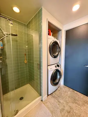 a bathroom with a shower and a washing machine at Penthouse Industrial Loft & Parking Little Italy in San Diego