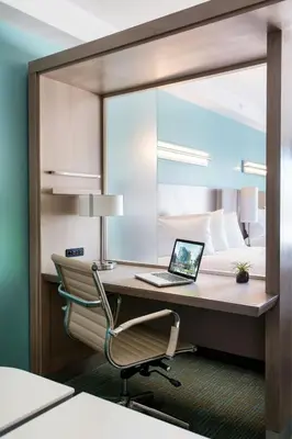 a bedroom with a desk with a laptop and a bed at SpringHill Suites by Marriott San Diego Downtown/Bayfront in San Diego