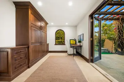 a hallway with a large wooden door and a desk at The Stratford - Del Mar Luxury Living in San Diego