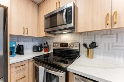 a kitchen with a stove and a microwave at Pier-View Penthouse Condo in Pacific Beach in San Diego