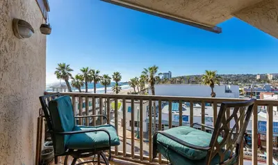 a balcony with two chairs and a view of the ocean at Pier-View Penthouse Condo in Pacific Beach in San Diego