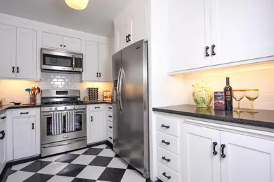 a kitchen with white cabinets and a stainless steel refrigerator at 4 Bdr 2 Bth in heart of Hilcrest 10 minutes from balboa park in San Diego