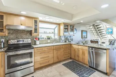 a kitchen with wooden cabinets and stainless steel appliances at 450A Ocean View beach house in Dana Point