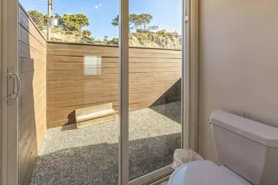 a bathroom with a toilet and a glass shower door at 450A Ocean View beach house in Dana Point