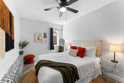 a white bedroom with a bed and a ceiling fan at The Treehouse by Coastline Vacation Rentals in San Diego