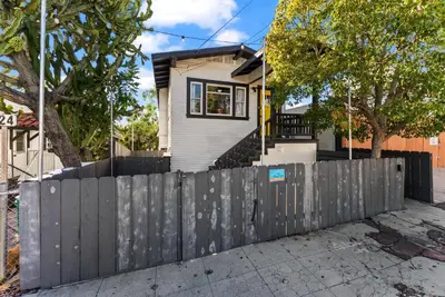 a house with a fence in front of it at The Treehouse by Coastline Vacation Rentals in San Diego