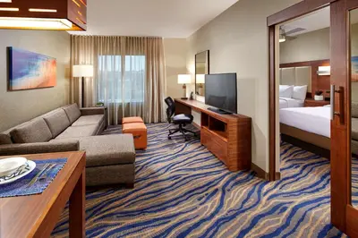 a hotel room with a couch and a bed and a television at Homewood Suites by Hilton San Diego Mission Valley/Zoo in San Diego