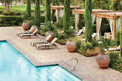 a patio with chairs and a swimming pool in a yard at Rancho Bernardo Inn in Rancho Bernardo