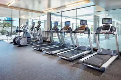 a gym with a row of treadmills and ellipticals at Homewood Suites by Hilton San Diego Downtown/Bayside in San Diego