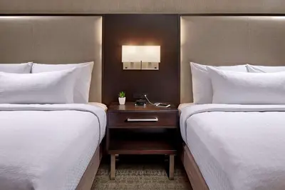 a hotel room with two beds and a nightstand between them at Homewood Suites by Hilton San Diego Downtown/Bayside in San Diego