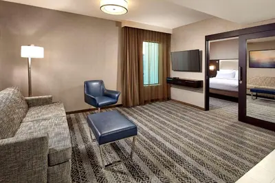 a hotel room with a couch and a tv and a bed at Homewood Suites by Hilton San Diego Downtown/Bayside in San Diego