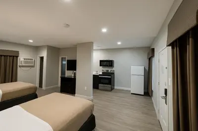 a hotel room with two beds and a kitchen at Rodeway Inn El Cajon - San Diego East in El Cajon