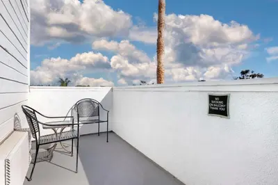 a balcony with a chair and a sign on a wall at Best Western Plus Marina Shores Hotel in Dana Point