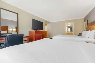a hotel room with two beds and a desk and a tv at Best Western Plus Marina Shores Hotel in Dana Point