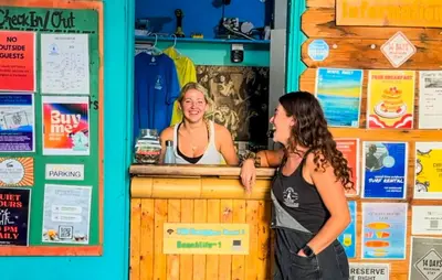 two women standing at a counter in a bar at ITH San Diego Beach Bungalow Surf Hostel in San Diego