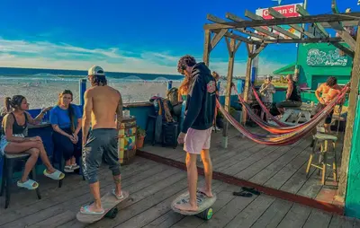 a group of people riding skateboards on a boardwalk at ITH San Diego Beach Bungalow Surf Hostel in San Diego