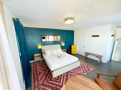 a bedroom with a bed and a blue wall at ITH San Diego Beach Bungalow Surf Hostel in San Diego