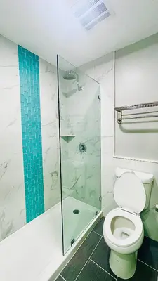 a bathroom with a toilet and a glass shower at Villa Serena in El Cajon