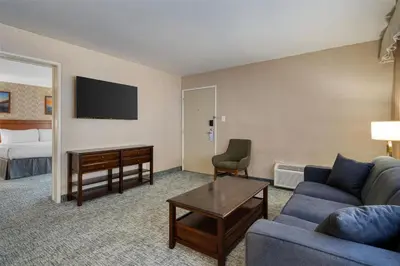 a living room with a couch and a desk and a bed at Best Western Seven Seas in San Diego