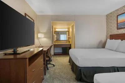 a hotel room with two beds and a flat screen tv at Best Western Seven Seas in San Diego