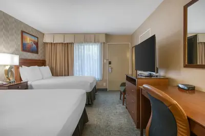 a hotel room with two beds and a desk and a television at Best Western Seven Seas in San Diego