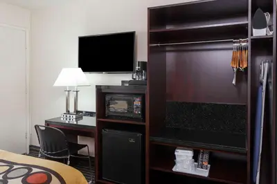 a hotel room with a large television and a desk at Super 8 by Wyndham San Diego Hotel Circle in San Diego