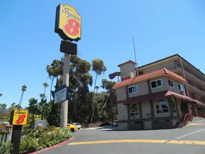 a sign on a pole in front of a building at Super 8 by Wyndham San Diego Hotel Circle in San Diego