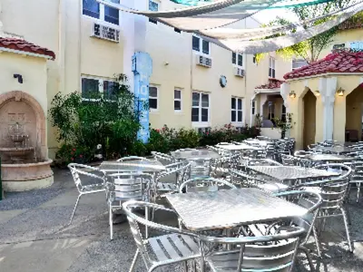 a group of tables and chairs in front of a building at El Primero Boutique Hotel in Chula Vista