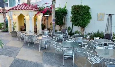 a group of tables and chairs in a patio at El Primero Boutique Hotel in Chula Vista