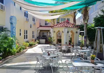 a patio with tables and chairs and a building at El Primero Boutique Hotel in Chula Vista