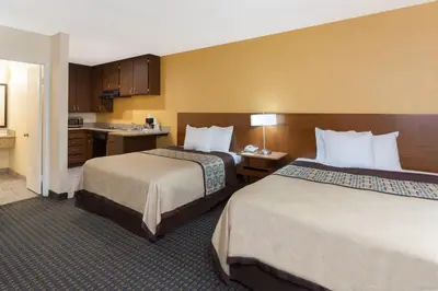 a hotel room with two beds and a kitchen at Days Inn by Wyndham Mission Valley-SDSU in San Diego