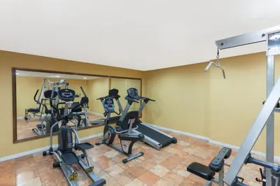 a gym with treadmills and ellipticals in a room at Days Inn by Wyndham Mission Valley-SDSU in San Diego