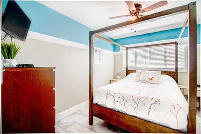 a bedroom with a bed and a ceiling fan at The Inn at Sunset Cliffs in San Diego