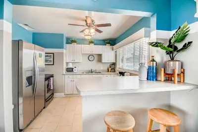 a kitchen with white cabinets and a ceiling fan at The Inn at Sunset Cliffs in San Diego