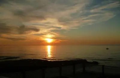 a sunset over the ocean with the sun in the sky at The Inn at Sunset Cliffs in San Diego