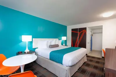 a bedroom with a large bed and a blue wall at Howard Johnson by Wyndham San Diego Hotel Circle in San Diego