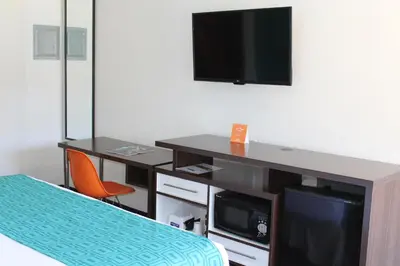 a room with a desk with a tv and a bed at Howard Johnson by Wyndham San Diego Hotel Circle in San Diego