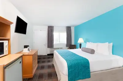 a hotel room with a bed and a flat screen tv at Howard Johnson by Wyndham San Diego Hotel Circle in San Diego