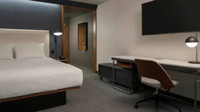 a bedroom with a bed and a desk with a computer at Courtyard by Marriott San Diego Miramar in San Diego