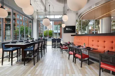 a restaurant with tables and chairs and windows at Hotel Indigo San Diego - Gaslamp Quarter by IHG in San Diego