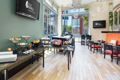 a dining room with tables and chairs and windows at Hotel Indigo San Diego - Gaslamp Quarter by IHG in San Diego