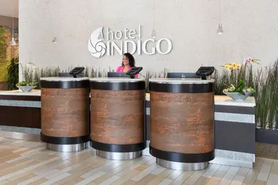 a woman sitting at a counter in a store with barrels at Hotel Indigo San Diego - Gaslamp Quarter by IHG in San Diego