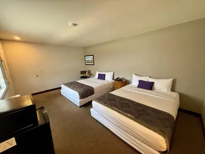 a hotel room with two beds with purple pillows at Heritage Inn San Diego in San Diego