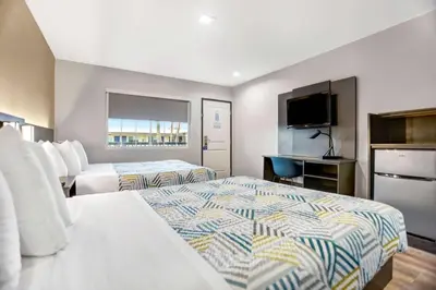 a hotel room with two beds and a flat screen tv at Motel 6 San Diego, CA Airport Harbor in San Diego