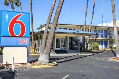 a sign in front of a hotel with palm trees at Motel 6 San Diego, CA Airport Harbor in San Diego