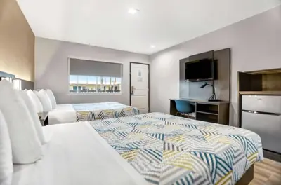a hotel room with two beds and a flat screen tv at Motel 6 San Diego, CA Airport Harbor in San Diego