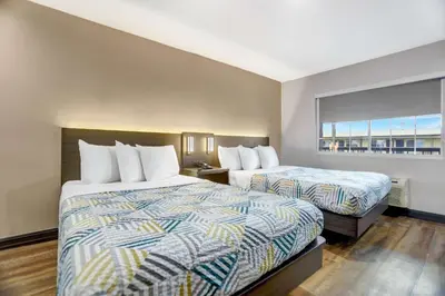 a hotel room with two beds and a window at Motel 6 San Diego, CA Airport Harbor in San Diego